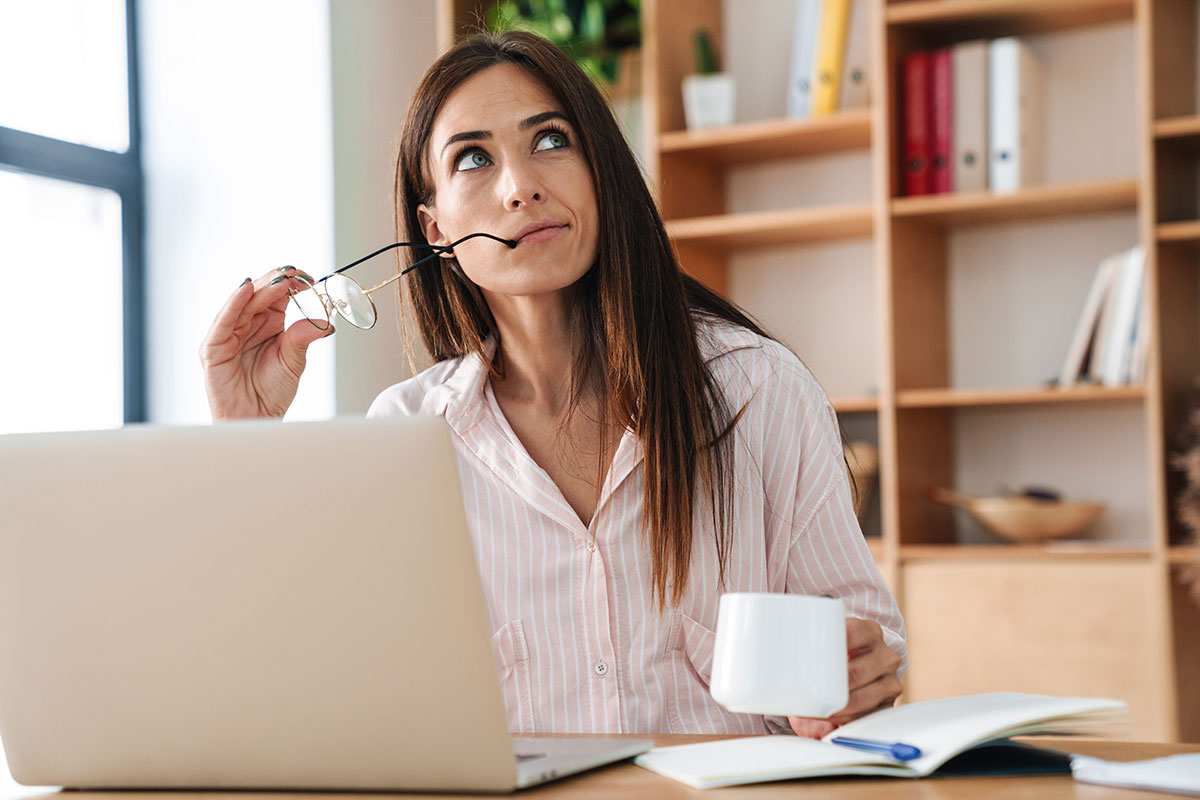 woman thinking while working on laptop